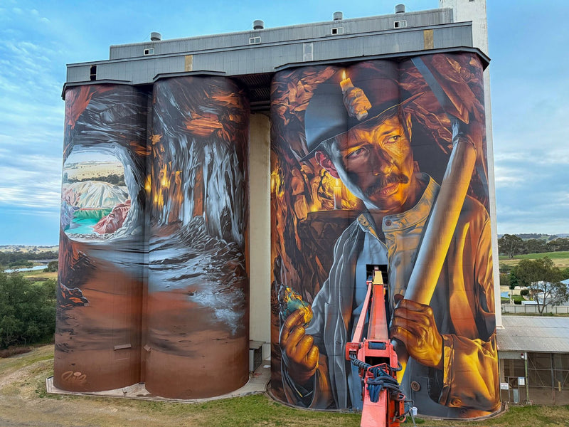 The Smug mural of a Cornish copper miner painted across the Kapunda grain silos in South Australia