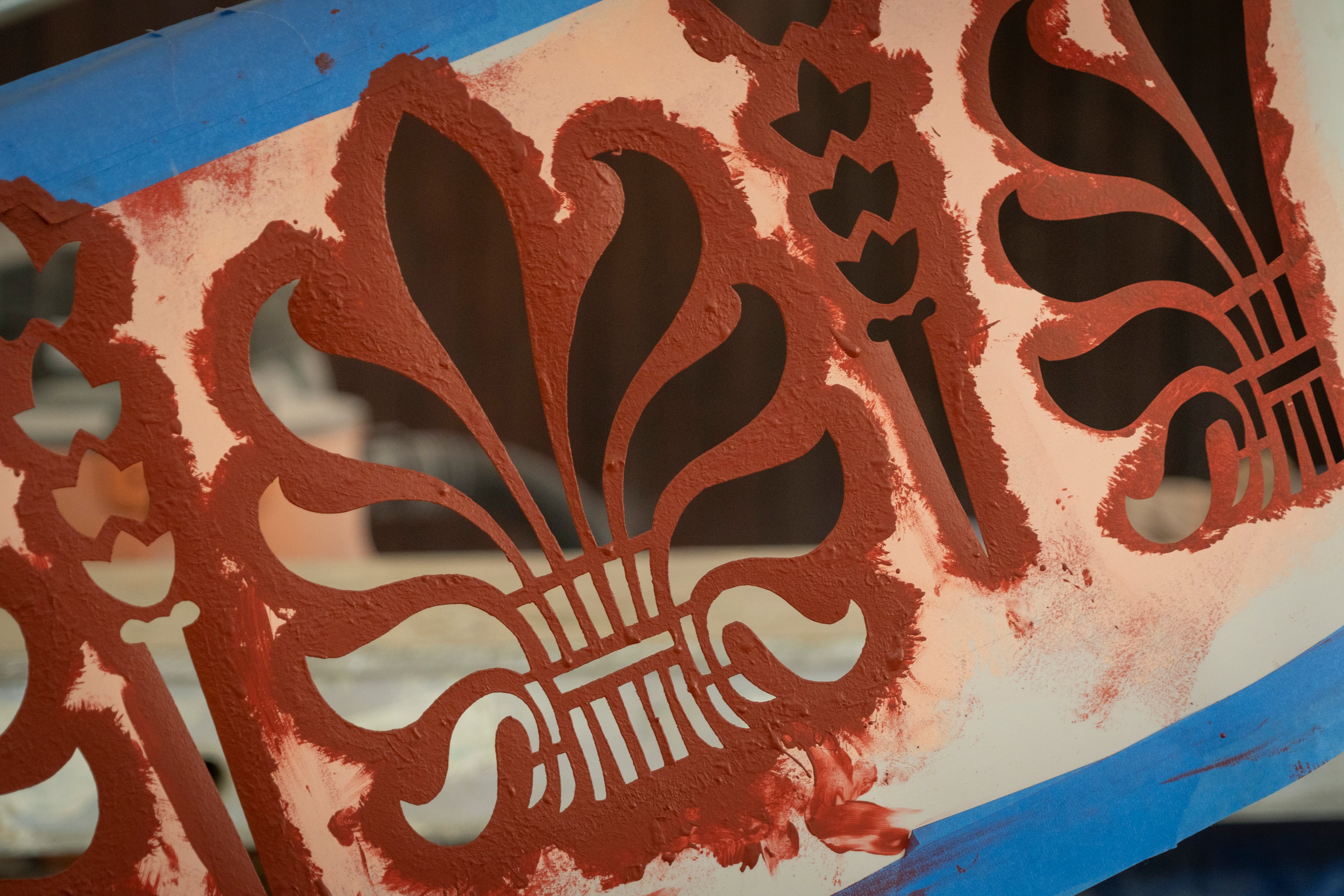 A stencil cut from a sheet of plastic, paint applied through the cut-out design