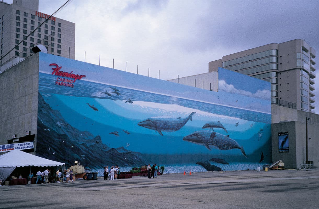 Wyland whale mural on a building wall, whales swimming across the wall