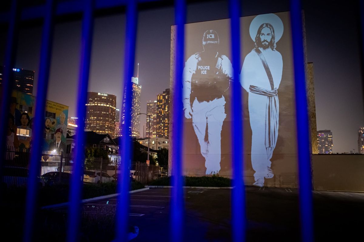 VJayBombs anti-ICE projection on a multistory building in downtown Los Angeles at night